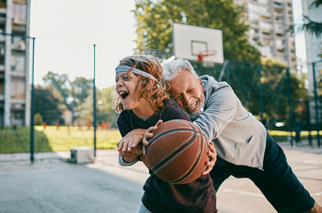 Junge spielt mit Opa Basketball